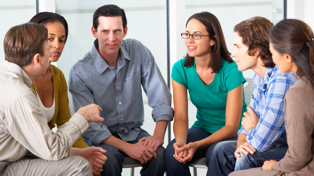 People talking to each other at a support group. Learn more about Narcotics Anonymous here.