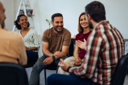A group of people talking to each other at a support group. Learn more about NA meetings, what they are, and where you can find one, here.
