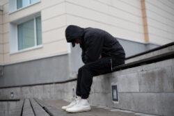 A sketchy looking man sitting on the curb. Learn more about Black Tar heroin here.