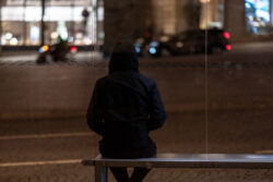 A man sitting on a bus stop bench in the city. Learn more about heroin street names and slang for heroin use here.