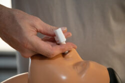 A person demonstrates how to administer naloxone on a dummy. Learn more about how naloxone helps treat a narcotics overdose here.