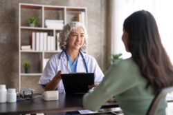 A woman speaking with a doctor. Learn more about methadone treatment alternatives here.