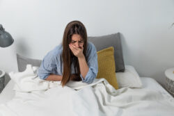 A woman feeling ill in bed. Learn more about tramadol side effects and signs of tramadol addiction here.