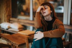 A person grips their nose in discomfort. Learn more about treatment for adderall addiction here.