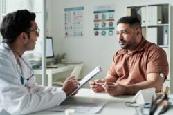 A man speaking with a doctor. Learn more about the dangers of heroin abuse here.